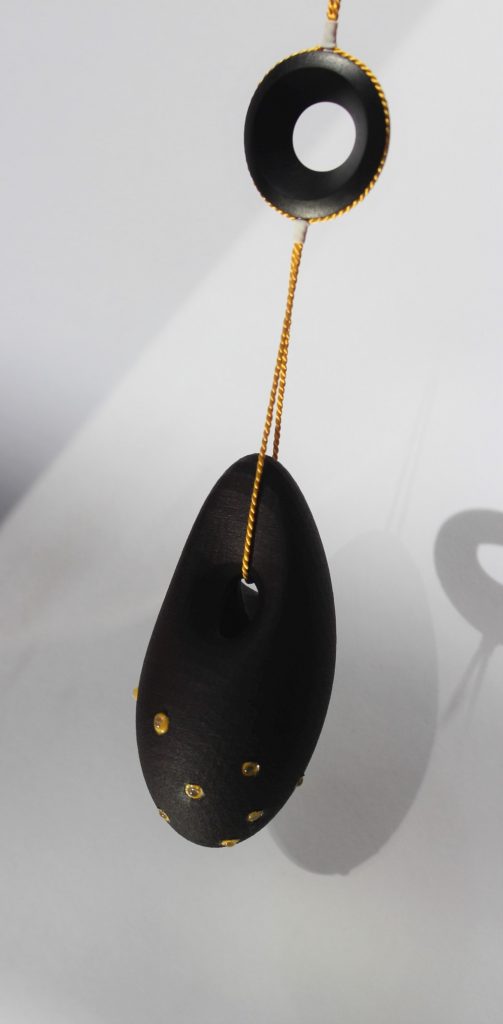 Pendant by Anne Boylan, 3D printed in polyamide, dyed black. set with stones.